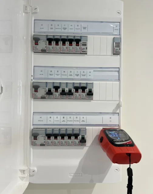 Tableau électrique blanc avec circuits étiquetés et appareil de contrôle
