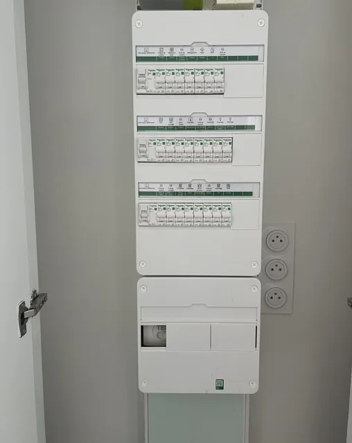 Tableau de distribution blanc à plusieurs rangées avec étiquettes de circuits